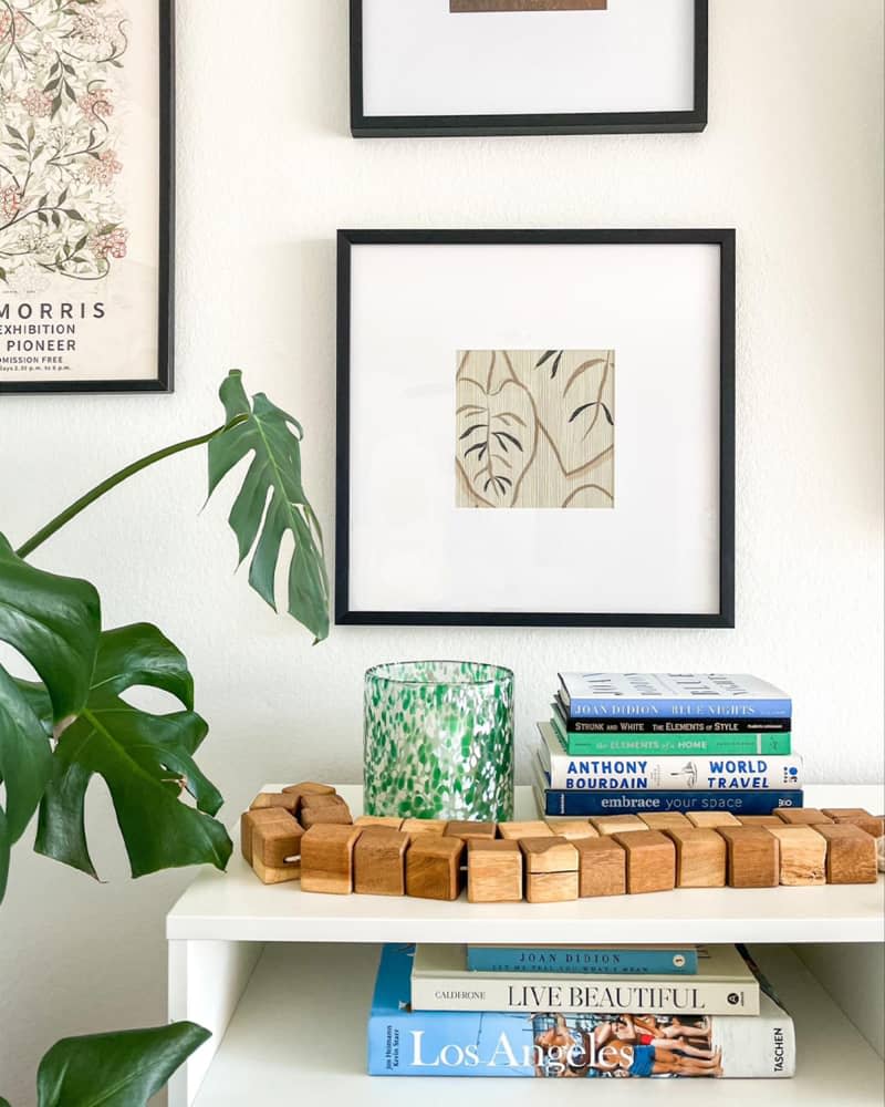 Framed wallpaper in gallery wall, wood blocks on on book shelf