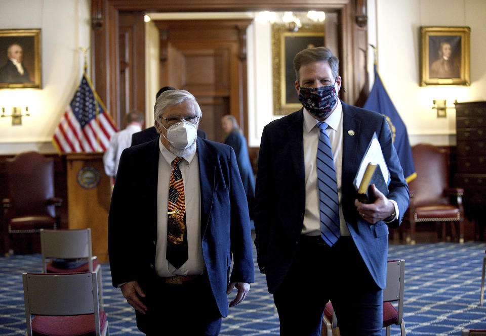 FILE - New Hampshire Gov. Chris Sununu walks with House Speaker Sherm Packard, R-Londonderry, at the State House in Concord, N.H., on Jan. 7, 2021. In New Hampshire, the 400-member House convened with Republicans holding a razor thin 201-197 majority, with two seats vacant. Slightly more Democrats than Republicans were absent last month when members chose their leader, though, which gave the GOP a bit of breathing room when it came to re-electing state Packard as House speaker. Gov. Sununu called the nearly even division a “awesome opportunity” for cooperation. (David Lane/The Union Leader via AP, Pool, File)