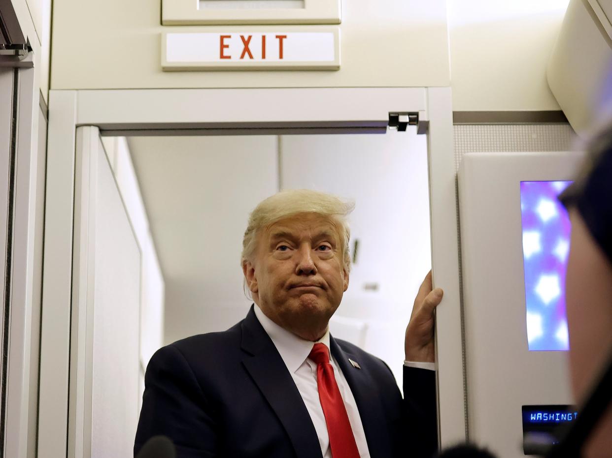 US President Donald Trump pauses as he talks to journalists on board Air Force One (REUTERS)