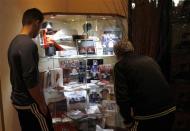 Two people look at a glass display containing memorial items of Brazilian Formula One driver Ayrton Senna at Castello hotel, where Senna spent his last night in Castel San Pietro, near the Imola race track April 22, 2014. REUTERS/Alessandro Garofalo