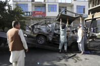 Security personnel remove a damaged minivan after a bomb explosion in Kabul, Afghanistan, Saturday, June 12, 2021. Separate bombs hit two minivans in a mostly Shiite neighborhood in the Afghan capital Saturday, killing several people and wounding others, the Interior Ministry said. (AP Photo/Rahmat Gul)