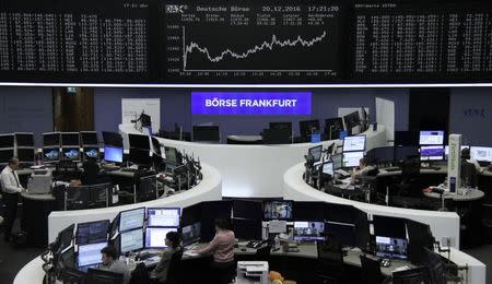 Traders work at their desks in front of the German share price index, DAX board, at the stock exchange in Frankfurt, Germany, December 20, 2016. REUTERS/Staff/Remote