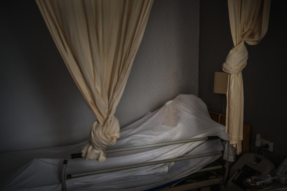 The body of an elderly person who died of COVID-19 is covered with a sheet on her bed in a nursing home in Barcelona, Spain, Nov. 13, 2020. The image was part of a series by Associated Press photographer Emilio Morenatti that won the 2021 Pulitzer Prize for feature photography. (AP Photo/Emilio Morenatti)