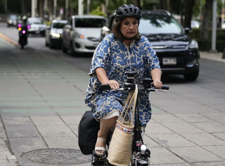 La senadora Xóchitl Gálvez, precandidata presidencial de la oposición derechista Frente Amplio por México, llega en bicicleta a un hotel en la Ciudad de México, el miércoles 9 de agosto de 2023, para conocer el avance de los aspirantes de esa coalición con vistas a los comicios de 2024 en México. (AP Foto/Fernando Llano)