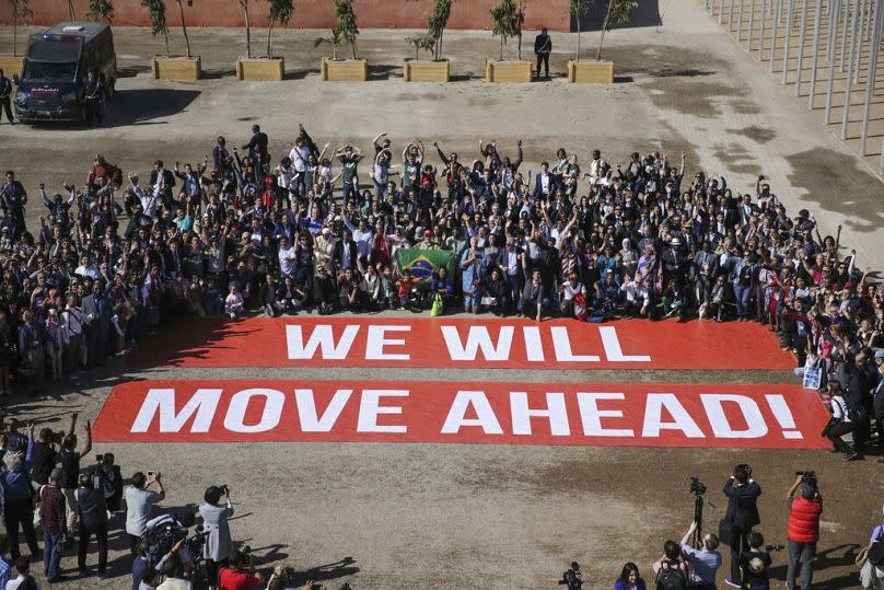 Les participants à la conférence sur le climat COP22 posent pour soutenir les négociations sur le climat et l'accord de Paris, le dernier jour de la conférence, à Marrakech