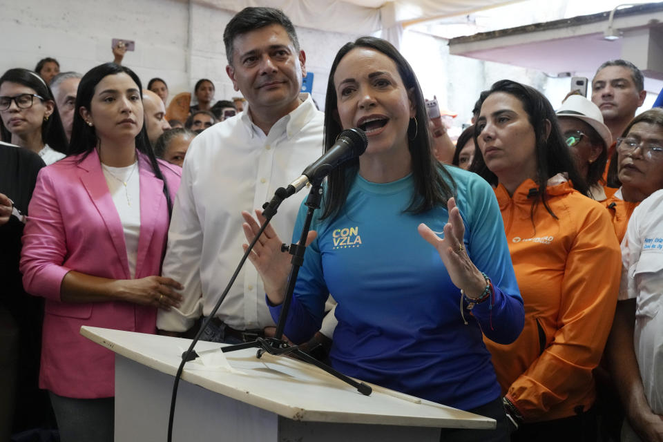 Opposition presidential hopeful Maria Corina Machado speaks to supporters after opposition leader Freddy Superlano, behind her, left, announced his withdrawal from the primaries in Caracas, Venezuela, Friday, Oct. 13, 2023. Superlano also announced the support of his party, Popular Will, for Machado ahead of the opposition's election to choose one candidate to face President Nicolas Maduro in 2024 at the polls. (AP Photo/Ariana Cubillos)