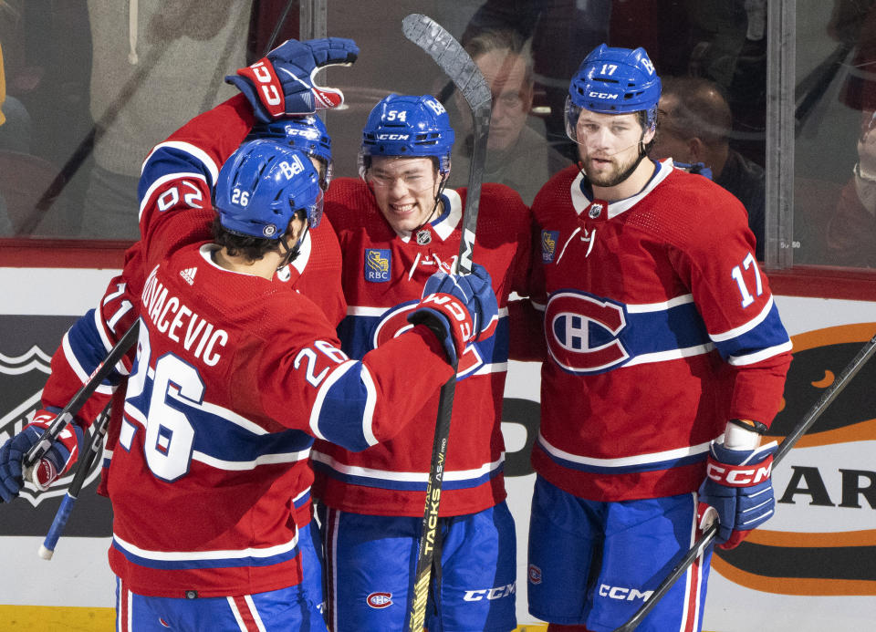 Montreal Canadiens' Jordan Harris (54) celebrates his goal against the Arizona Coyotes with Johnathan Kovacevic (26), Jake Evans, hidden, and Josh Anderson (17) during the second period of an NHL hockey game Tuesday, Feb. 27, 2024, in Montreal. (Christinne Muschi/The Canadian Press via AP)