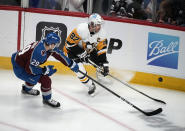 Pittsburgh Penguins center Sidney Crosby, right, fights for control of the puck with Colorado Avalanche center Nathan MacKinnon in the first period of an NHL hockey game Wednesday, March 22, 2023, in Denver. (AP Photo/David Zalubowski)