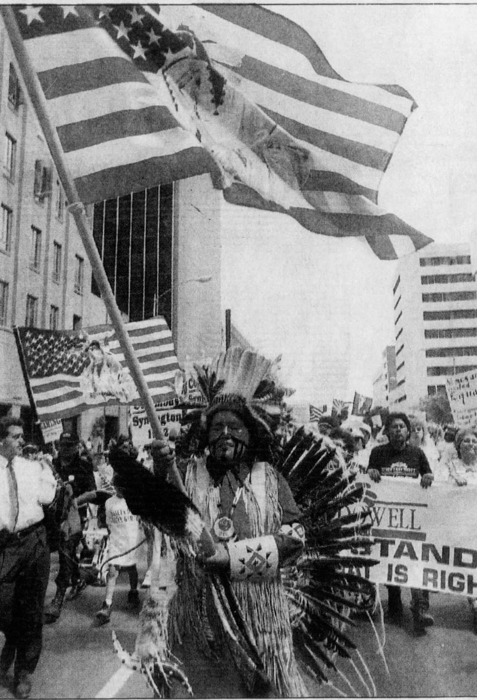 Chris Rhodes of Phoenix, clad in traditional northern Plains Indian regalia, joins a protest march to the state Capitol. (Published May 21, 1992)