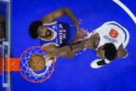 New York Knicks' OG Anunoby (8) dunks past Philadelphia 76ers' Joel Embiid, left, during the second half of Game 6 in an NBA basketball first-round playoff series, Thursday, May 2, 2024, in Philadelphia. (AP Photo/Matt Slocum)