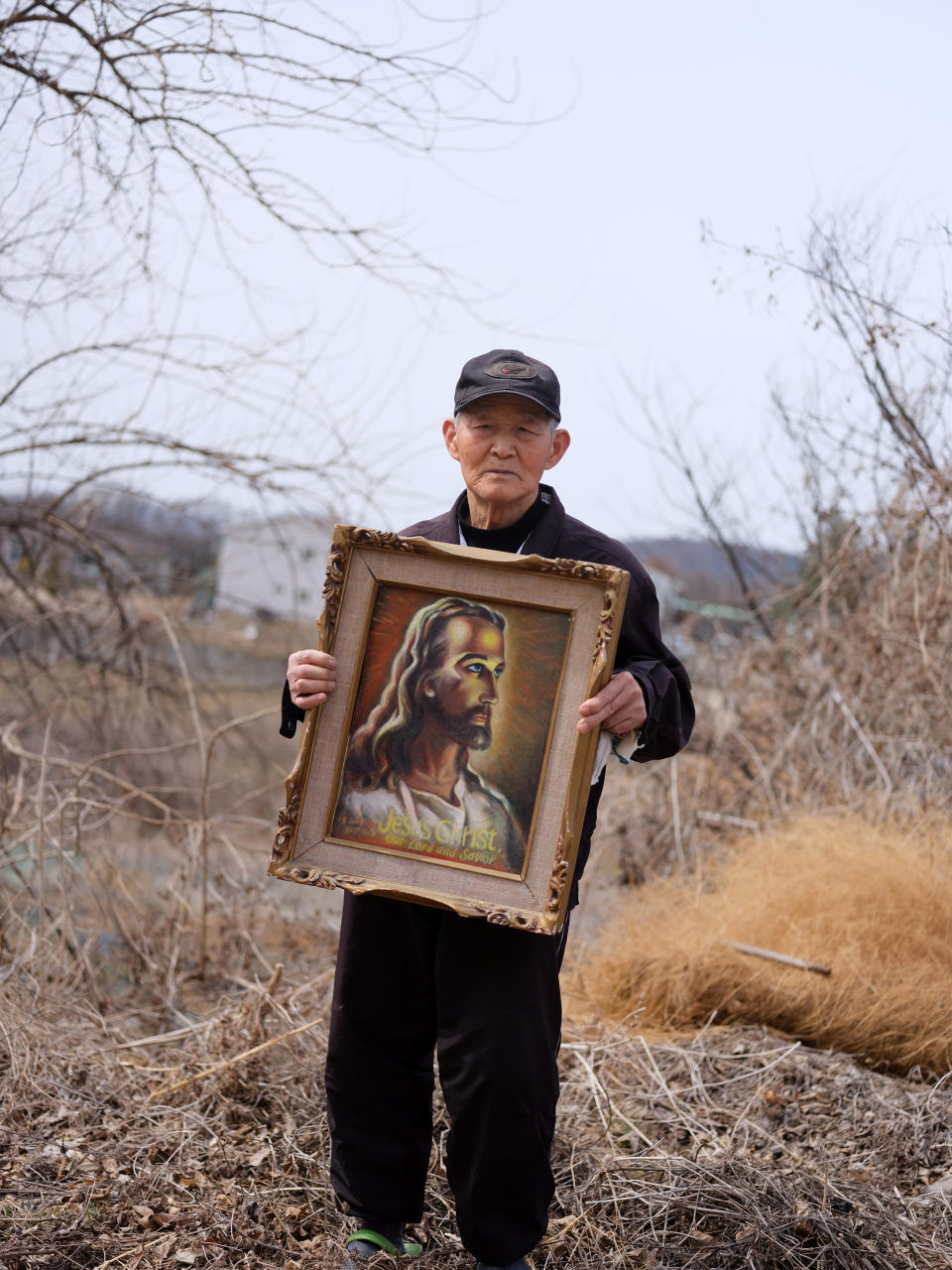 Yoon Seok-sahn, who was separated from his family in the North, poses near his home in Tongilchon.
