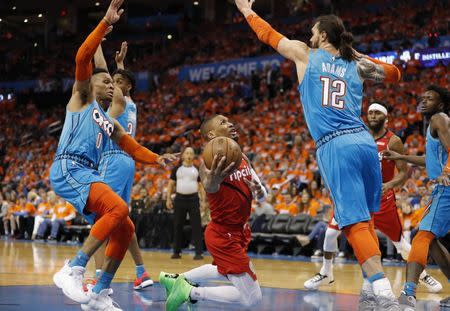 Apr 19, 2019; Oklahoma City, OK, USA; Portland Trail Blazers guard Damian Lillard (middle) shoots against Oklahoma City Thunder guard Russell Westbrook (left) and center Steven Adams (right) during the second half in game three of the first round of the 2019 NBA Playoffs at Chesapeake Energy Arena. Mandatory Credit: Alonzo Adams-USA TODAY Sports