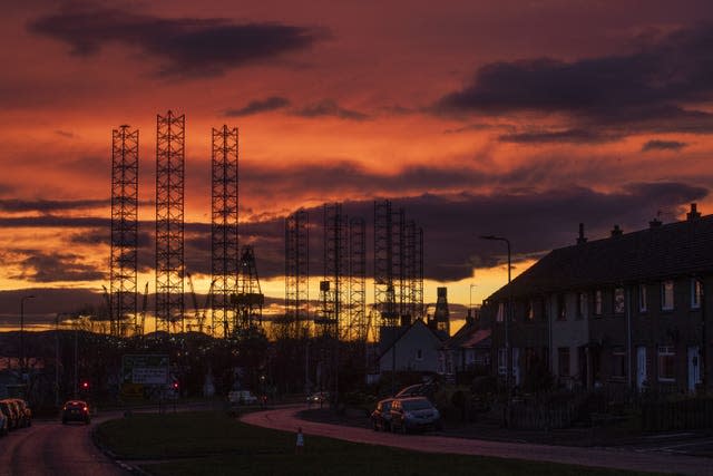 Jackup rigs, used in the North Sea oil and gas industry, are silhouetted against the sky at sunset over the Port of Dundee (Jane Barlow/PA)