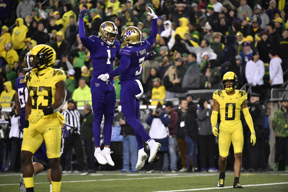 Washington wide receiver Taj Davis (3) celebrates with wide receiver Rome Odunze (1) after scoring as Oregon linebacker Jeffrey Bassa (33)  and defensive back Christian Gonzalez (0) look on during the second half of an NCAA college football game Saturday, Nov. 12, 2022, in Eugene, Ore. (AP Photo/Andy Nelson)