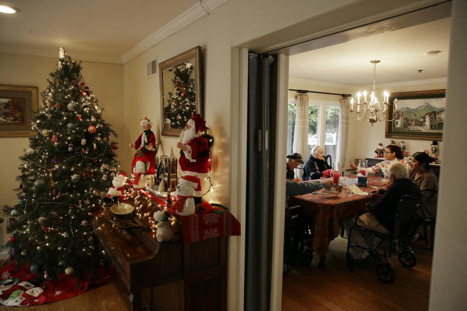 In this photo taken Thursday, Dec. 5, 2019, residents at the Cedars Care Home working on an afternoon activity of writing Christmas cards in Calistoga, Calif. An Associated Press review shows widespread problems with the four “public safety power shutoffs” the utility started rolling out in 2018, a year before massive blackouts paralyzed much of California in recent months. Interviews and documents obtained under public records requests reveal persistent failures and broken promises that in some cases compromised public safety.(AP Photo/Eric Risberg)