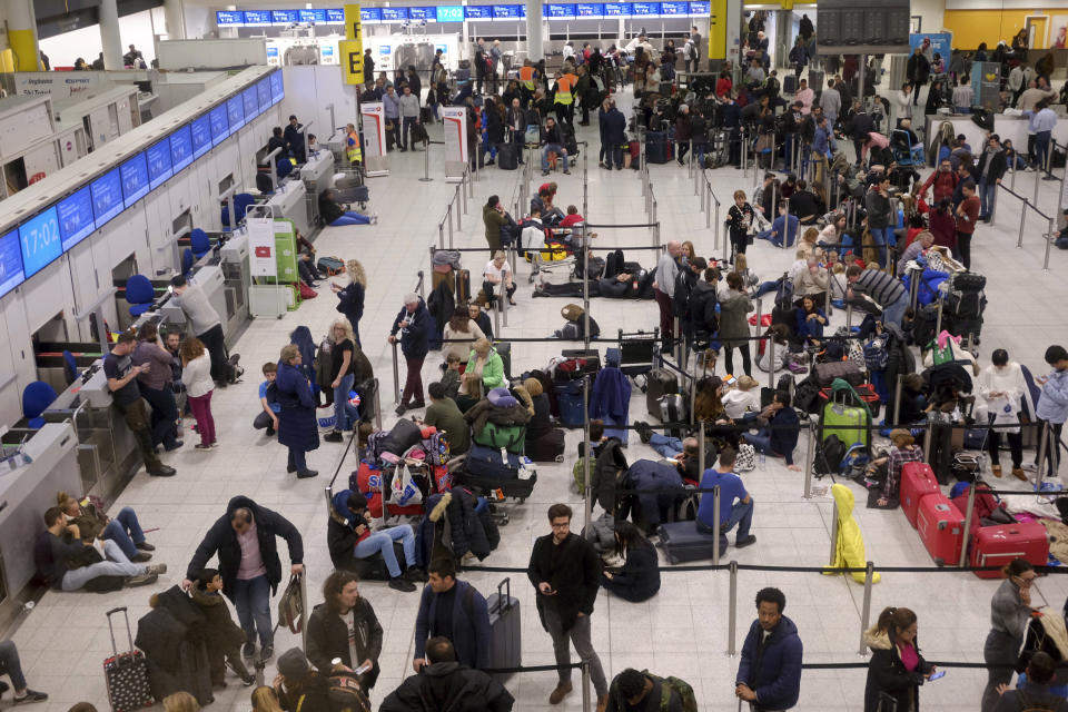 People wait in the departures area at Gatwick airport, as the airport remains closed after drones were spotted over the airfield last night and this morning, in Gatwick, England, Thursday, Dec. 20, 2018. Drones spotted over the runway forced the shutdown of London's Gatwick Airport on Thursday during one of the busiest times of the year, stranding or delaying tens of thousands of Christmas-season travelers and setting off a hunt for the operator of the intruding aircraft. (AP Photo/Tim Ireland)