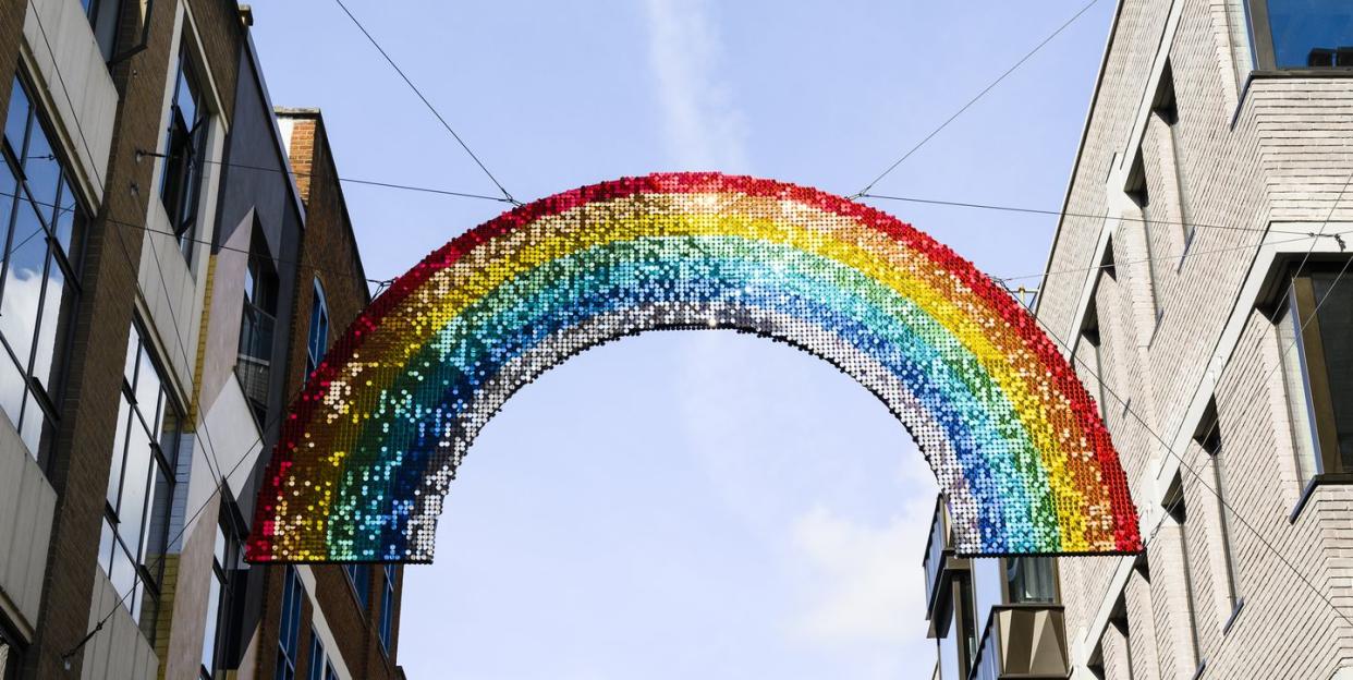 uk, london, rainbow colour decoration hanging from buildings at carnaby street