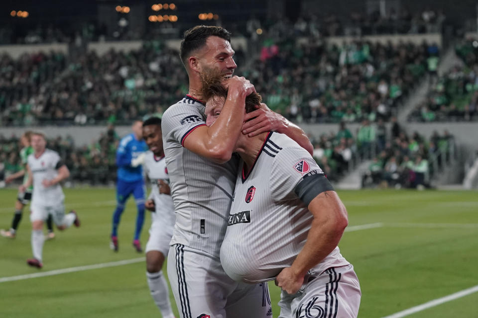 St Louis City FC Tim Parker, right, holds the ball under his jersey as he celebrates his goal against the Austin FC with teammate Eduard Lowen, left, during the first half of an MLS soccer match in Austin, Texas, Saturday, Feb. 25, 2023. (AP Photo/Eric Gay)