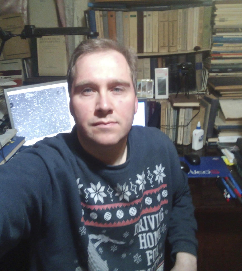 This March 2022 selfie photo provided by astronomer Ivan Slyusarev shows him in his home office in Kharkiv, Ukraine. He no longer has access to data from the Kharkiv National University's observatory, which is now in Russian-occupied territory. Slyusarev is using data from a colleague's telescope in the Czech Republic to continue his work analyzing metallic asteroids. (Ivan Slyusarev via AP)