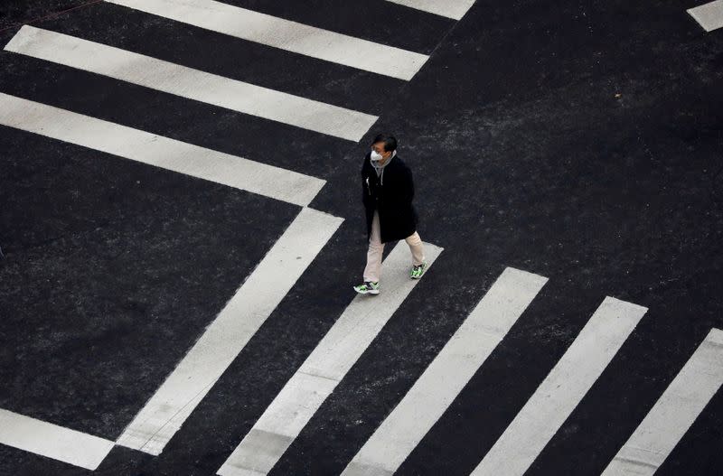 A man wearing a mask to prevent contracting the coronavirus walks on a zebra crossing in Seoul