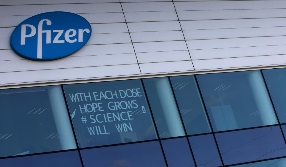 ARCHIVO - En esta imagen del martes 23 de febrero de 2021, un cartel colocado en una ventana de un centro de manufactura de Pfizer en Puurs, Bélgica. El cartel dice "Con cada dosis crece la esperanza, ganará la ciencia". La Comisión Europea finalizó un tercer contrato de vacunas con Pfizer y BioNTech hasta 2023 por otros 1.800 millones de dosis de su vacuna contra el COVID-19. (AP Foto/Virginia Mayo, Archivo)