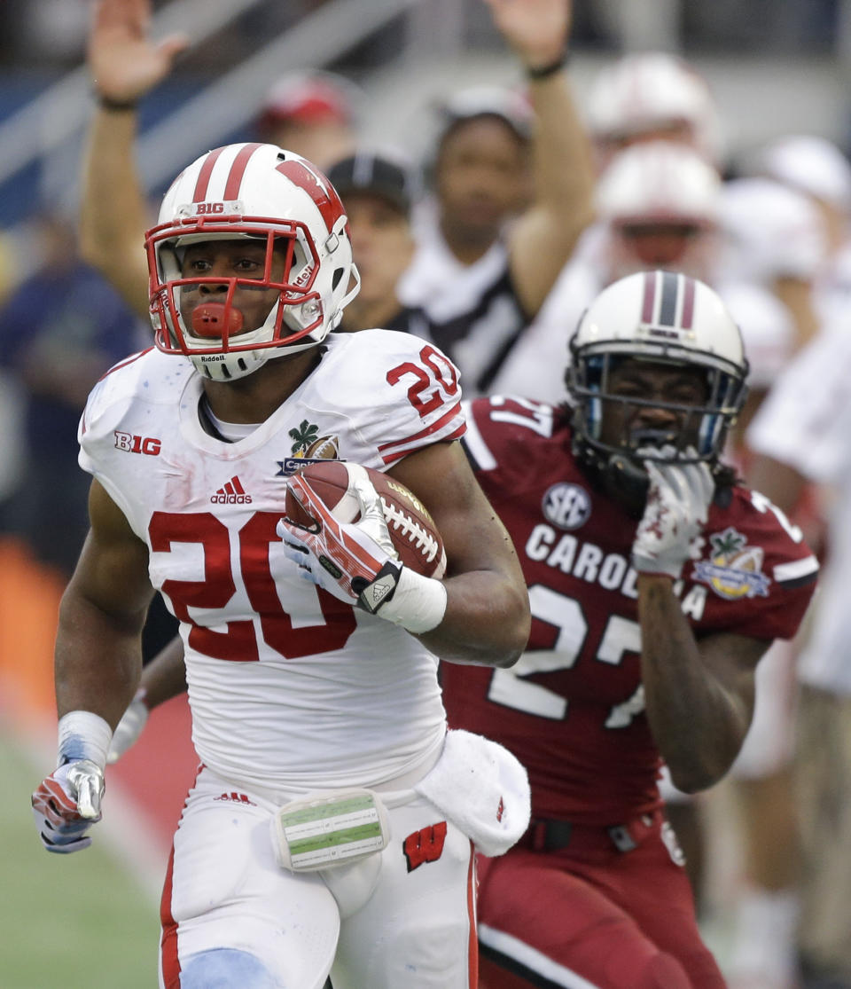 Wisconsin running back James White (20) gets past South Carolina cornerback Victor Hampton (27) for a short gain during the first half of the Capital One Bowl NCAA college football game in Orlando, Fla., Wednesday, Jan. 1, 2014.(AP Photo/John Raoux)
