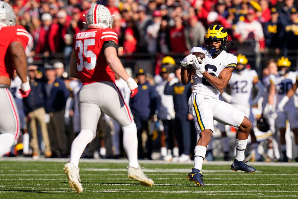 Michigan receiver Cornelius Johnson catches a pass behind Ohio State linebacker Tommy Eichenberg.