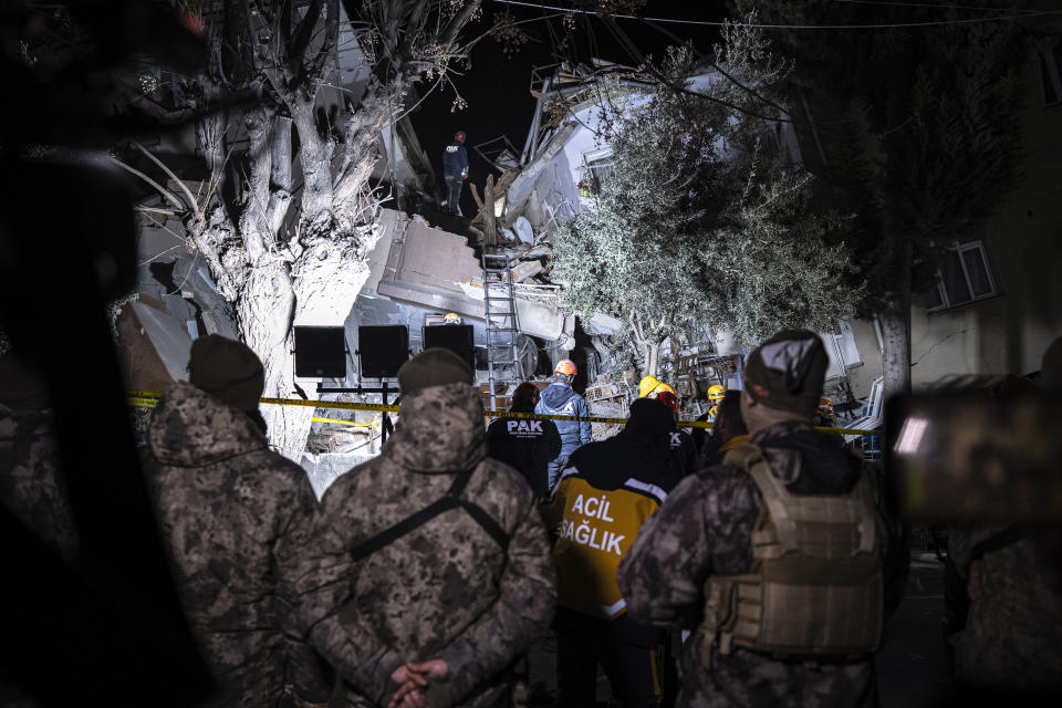 Rescue team members search for people in a destroyed building during the aftermath of an earthquake in Hatay, Turkey, Monday, Feb. 20, 2023. A new 6.4 magnitude earthquake on Monday struck parts of Turkey and Syria that were laid waste two weeks ago by a massive quake that killed around 45,000 people. Officials said more buildings collapsed, trapping occupants, and several people were injured in both countries. (Ugur Yildirim/DIA via AP)