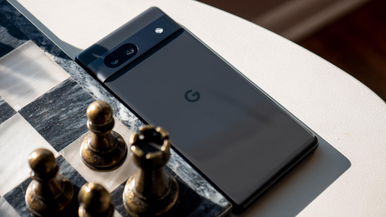  The Charcoal Google Pixel 7a next to a marble and metal chess board. 