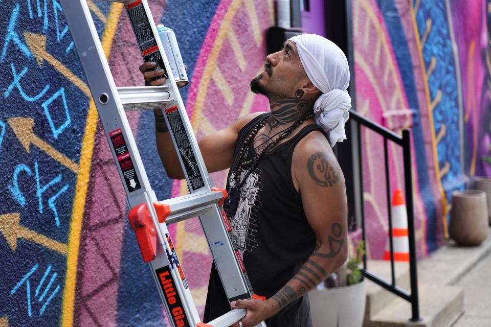 June 13, 2022; Columbus, Ohio; Local mural artist and tattoo artist Carlos Roa moves his ladder as he puts the finishing touches to his stunning mural at Parsons Ave. and Stewart Ave. on the South Side.