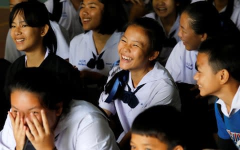 Classmates react with joy after a teacher announces that some of the 12 schoolboys who were trapped inside a flooded cave, have been rescued, at Mae Sai Prasitsart school, in the northern province of Chiang Rai - Credit: Tyrone Siu/Reuters