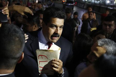 Venezuela's President Nicolas Maduro (C) greets supporters after his meeting with representatives of the Venezuelan coalition of opposition parties Mesa de la Unidad (MUD) and the Union of South American Nations' (UNASUR) foreign ministers in Caracas April 8, 2014. REUTERS/Carlos Garcia Rawlins