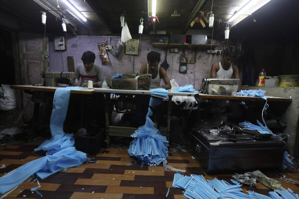 Indian workers make face masks which are in demand due to the new virus outbreak at a private manufacturing unit in Mumbai, India, Tuesday, March 17, 2020. For most people, the new coronavirus causes only mild or moderate symptoms. For some it can cause more severe illness. (AP Photo/Rafiq Maqbool)