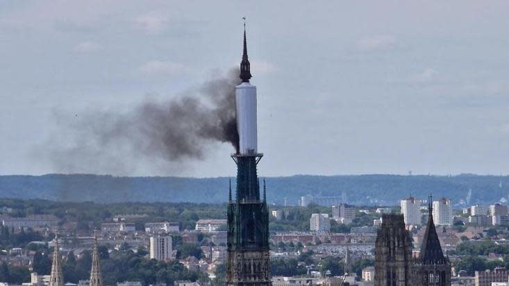Smoke billows from the spire of Rouen Cathedral in Rouen, northern France.