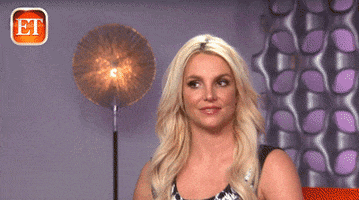 Britney Spears in a TV interview, smiling, as the camera zooms in
