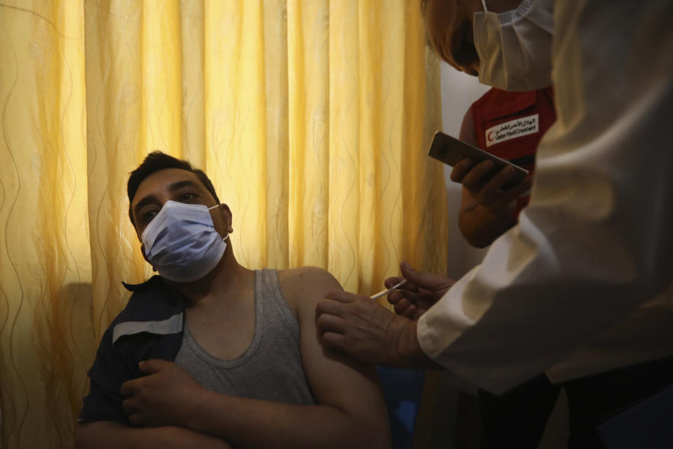A Syrian man receives AstraZeneca COVID-19 vaccine, at Ibn Sina Hospital, in Idlib town, northwestern Syria, Saturday, May 1, 2021. The inoculation campaign against COVID-19 kicked off in Syria's last rebel-held enclave in the country's northwest, with a 45-year-old front line nurse becoming the first to receive the UN-secured Jabs on Saturday. (AP Photo/Ghaith Alsayed)