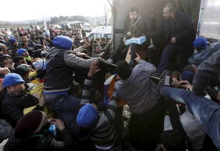 Stranded migrants fight over goods given away by locals at the Greek-Macedonian borders near the village of Idomeni, Greece, November 28, 2015. Picture taken from the Greek side of the border. REUTERS/Yannis Behrakis