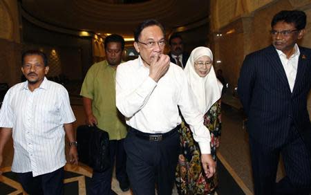 Malaysian opposition leader Anwar Ibrahim (C) and his wife Wan Azizah arrive at a court house in Putrajaya March 7, 2014. REUTERS/Samsul Said