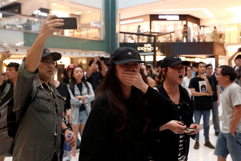 Shoppers and anti-government protesters gather at New Town Plaza in Sha Tin, Hong Kong