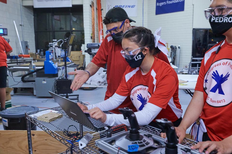 Liz Seaton and Juan Palomino work to figure out why Red Bull was overshooting its mark when trying to lift itself off the ground at Si Se Puede Foundation STEM Center in Chandler on April 13, 2022.