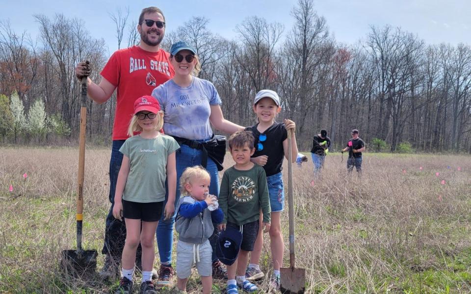 A family poses with their shovels at Red-tail’s 2022 Earth Day Tree Planting