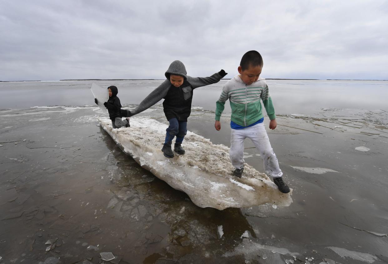 Schoolchildren play on melting ice at Yupik Eskimo village of Napakiak on the Yukon Delta in Alaska on April 19, 2019. (Mark Ralston/AFP via Getty Images)