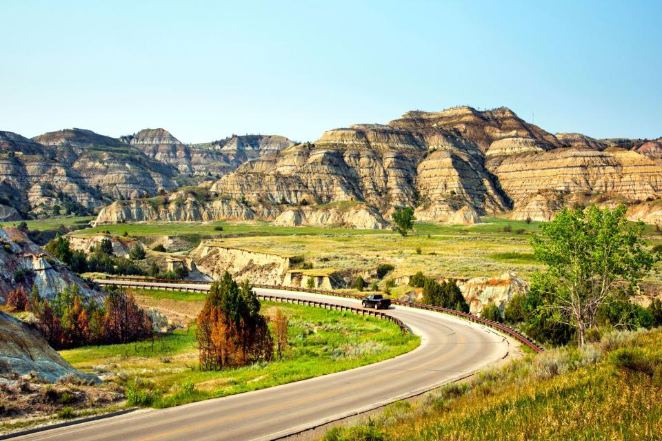 Road winds through the badland terrain of Theodore Roosevelt National Park, North Unit, in North Dakota