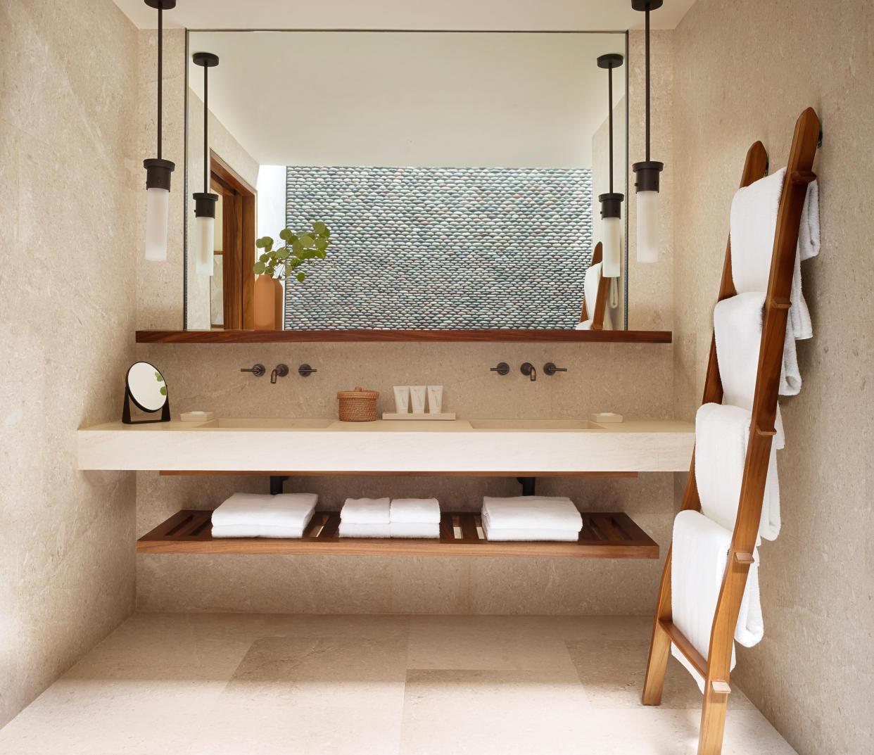  A bathroom floating shelf with neatly folded towels. 