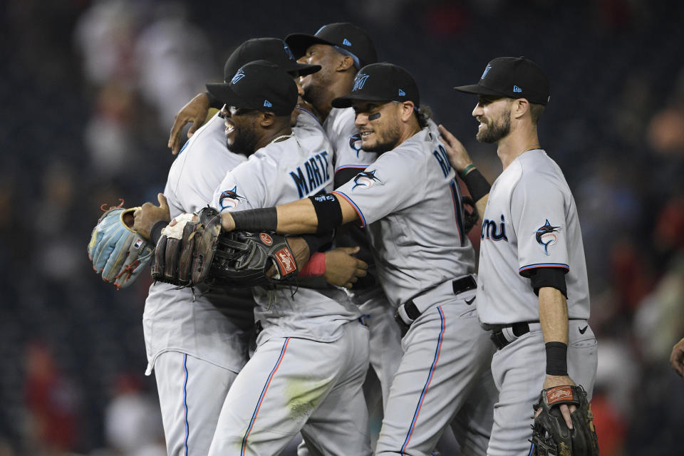 Miami Marlins' Starling Marte, second from left, Miguel Rojas, second from right, and others celebrate after the team's 3-1 win over the Washington Nationals in a baseball game Wednesday, July 21, 2021, in Washington. (AP Photo/Nick Wass)