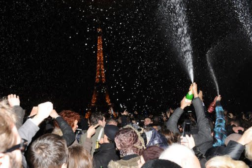 People spray champagne as they celebrate the New Year on the Trocadero square in front of the Eiffel Tower in Paris