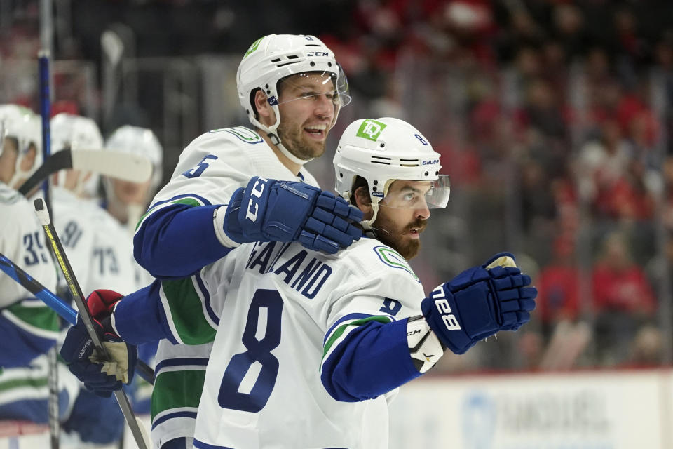 Vancouver Canucks right wing Conor Garland (8) celebrates his goal with Tucker Poolman (5) against the Detroit Red Wings in the second period of an NHL hockey game Saturday, Oct. 16, 2021, in Detroit. (AP Photo/Paul Sancya)