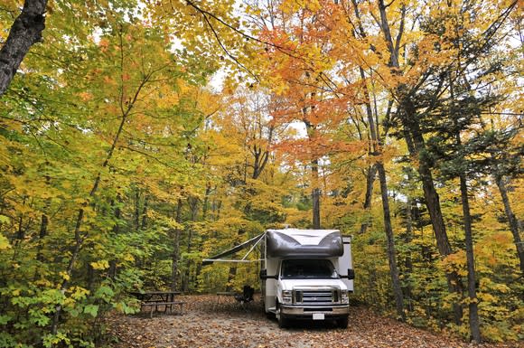 A recreational vehicle camping in a forrest.