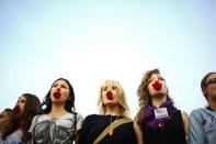 Women hold carnations in their mouth as a sign of protest during the Slut Walk, in Bucharest, Romania. The Slut Walk is an idea that started in Canada as a protest against discrimination and harassment towards women, because of the way they would dress or behave in public