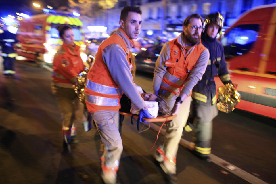 FILE - In this Nov. 13, 2015, file photo, a woman is being evacuated from the Bataclan concert hall after a shooting in Paris. France is commemorating the fourth anniversary of the Islamic State attacks in Paris. The attacks on Nov. 13, 2015, left 131 people dead at the country's national stadium, the Bataclan concert hall and bars and restaurants in the city center. (AP Photo/Thibault Camus, File)